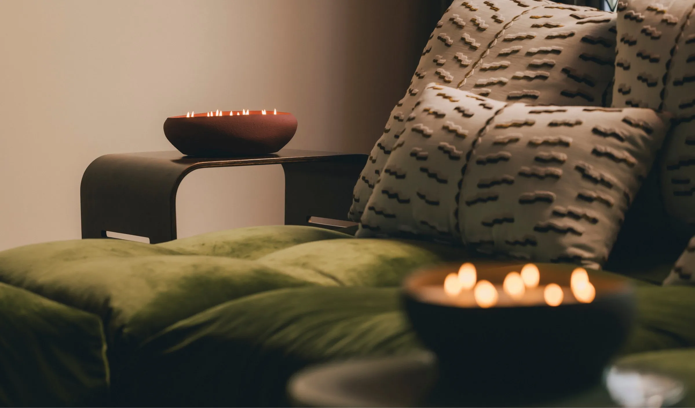 Doteki candles glowing on a moss-green sofa