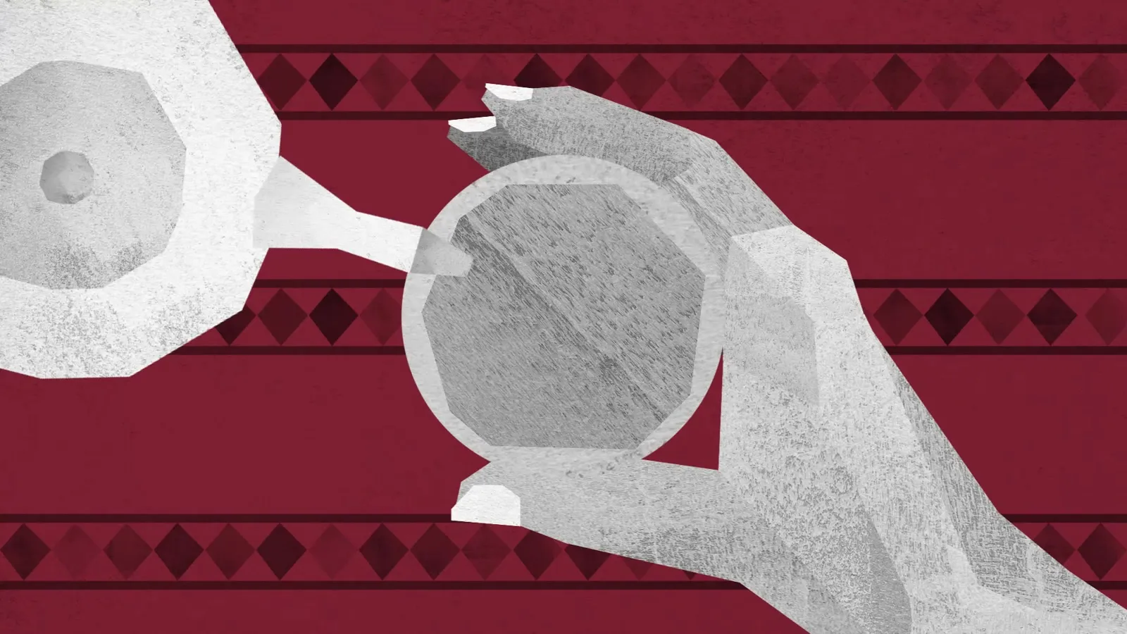A hand holding a glass of mint tea over a red rug